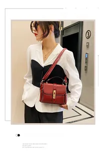 Dettaglio della borsa bordeaux in pelle cerata con finiture dorate in contesto lifestyle