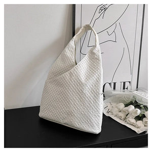 Detailansicht einer weißen gesteppten Hobo-Tasche mit Strukturstoff auf schlichtem Dekor