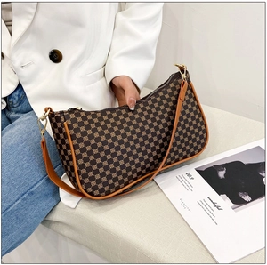 Dettaglio della borsa a mezzaluna vintage con motivi floreali e tracolla