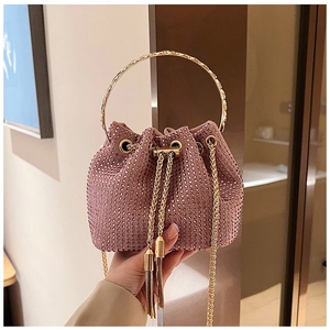 Gros plan sur le sac seau en strass or rose avec poignée en anneau métallique doré