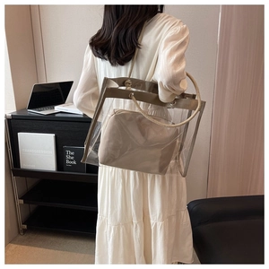 Detail of transparent PVC tote bag featuring rope handles and a beige inner pouch
