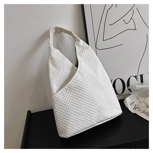 Detailansicht der weißen gesteppten Waffelstruktur und Dreiecksform der Schultertasche
