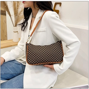 Borsa a luna monogramma marrone indossata con blazer bianco e jeans per un look casual