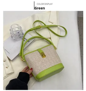 Detail of green leather and woven straw bucket bag featuring a gold twist lock closure