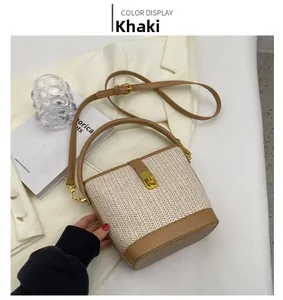 Detail view of khaki straw bucket bag with golden twist lock and leather trim on white suit