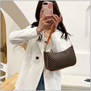 Dettaglio della borsa a mezzaluna con motivo vintage e rifiniture in pelle arancione