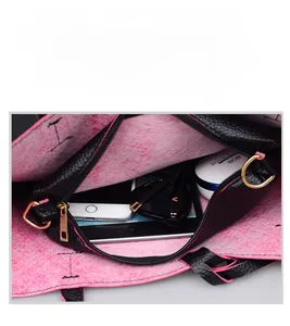 Detail showing the large capacity black leather tote with bright pink felt lining