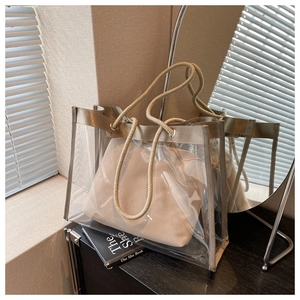 Detail of transparent PVC tote with thick rope handles and beige canvas inner pouch