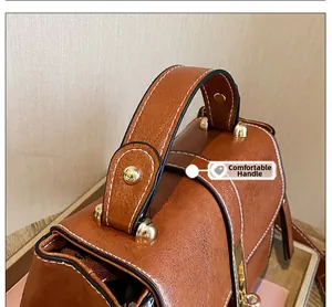 Dettaglio del manico comodo della borsa in pelle marrone retrò con borchie dorate