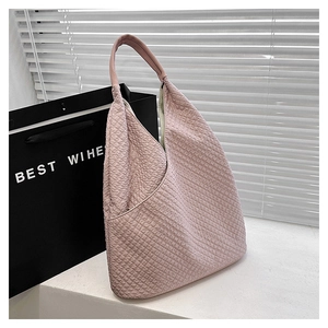 Detail der rosa Waffelstruktur auf einer minimalistischen sichelförmigen Schultertasche