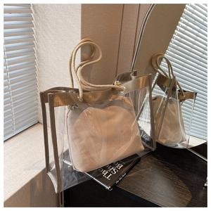 Detail of the golden trim and rope handle on a transparent PVC jelly tote bag