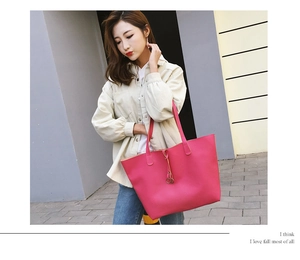 Outdoor shot of a rose red tote bag with lychee grain texture on a neutral urban wall