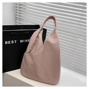 Detail der rosa Waffelstruktur und des weichen, integrierten Griffs der Handtasche