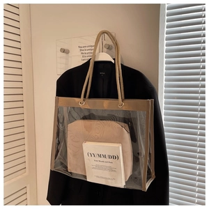 Close-up of clear PVC tote bag with rustic hemp rope handles and beige inner pouch