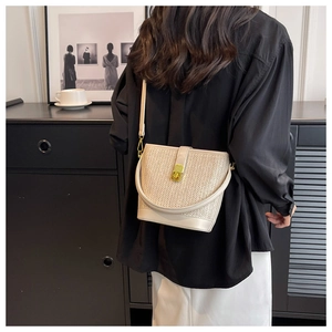 Close-up of bohemian straw tote bag featuring woven texture and gold twist-lock closure