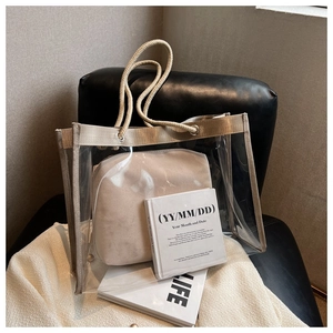 Close-up of clear PVC tote bag with thick cotton rope handles and beige inner pouch