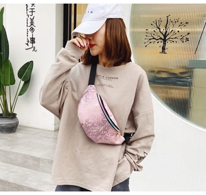 Détail du motif crocodile rose nacré avec chaîne métallique sur le sac de ceinture chic