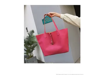 Detailed view of a pink textured leather tote bag with stylish thin straps and drawstring tie