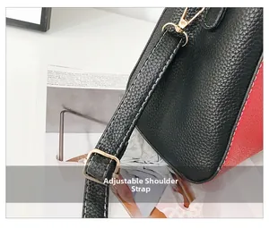 Détail de la bandoulière réglable en cuir noir avec boucle dorée sur le sac bicolore