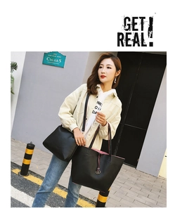 Detail of black pebbled leather tote and crossbody bag set shown in outdoor street style