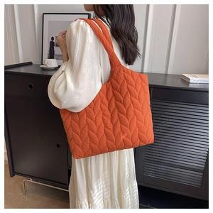 Detail der orangefarbenen Stepptasche mit Blattmuster-Nähten und großem Fassungsvermögen