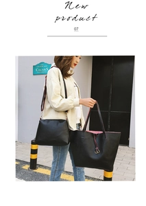 Detail of black pebbled leather tote bag set with contrasting ribbon shoulder strap