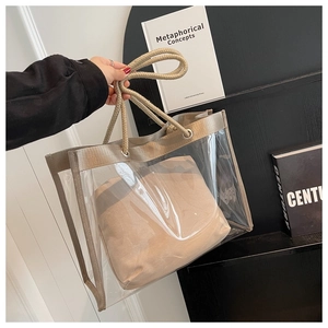 Detail of transparent PVC tote bag with gold woven handles and a canvas inner pouch