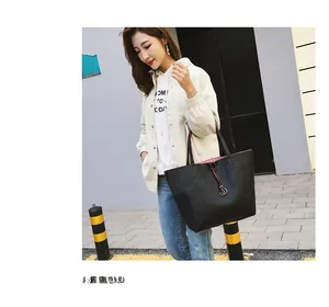 Detail view of large capacity black leather tote with pink lining and metal drawstring