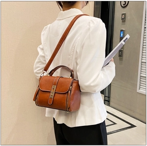 Elegante borsa a tracolla in pelle cerata color caramello con fibbia e cuciture a contrasto