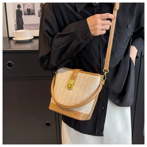 Detailed close-up of straw bucket bag featuring V-shaped texture and gold metal turn-lock