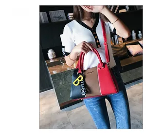 Détail de la couture tricolore et de la texture litchi sur ce sac à bandoulière chic