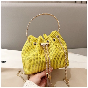 Vue détaillée du sac seau jaune avec ornements en strass denses et cordon de serrage doré