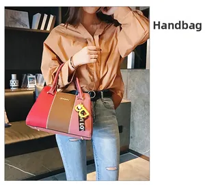 Gros plan d'un sac à main bicolore en cuir grainé avec plaque logo en métal doré