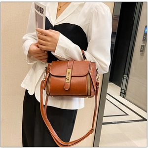Dettaglio della borsa in pelle cerata caramello con chiusura dorata e zip decor