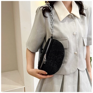 Vue détaillée du sac croissant en strass noirs avec chaîne argentée sur blazer gris