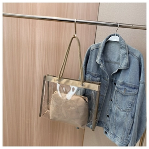 Detail of transparent tote bag with rope handles and beige inner pouch on a hanger