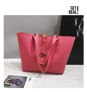 Detail of rose red lychee grain leather tote bag featuring a decorative metal ring drawstring
