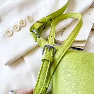 Detailansicht der lindgrünen Ledertasche mit Narbenleder und verstellbarer Silberschnalle