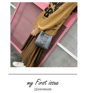 Grey PU leather crossbody bag with gold chain strap shown on a yellow hoodie
