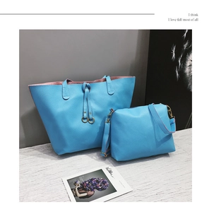 Detail of bright blue litchi grain tote bag and crossbody set with golden hardware
