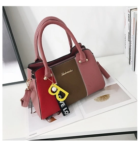 Détail du sac à main tricolore en cuir avec logo métallique et breloque lettre B