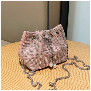 Détail du sac seau rose en strass avec fermeture à cordon et breloques en perles