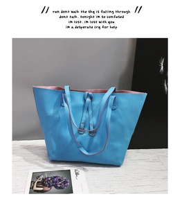 Detailed view of sky blue lychee textured tote bag with pink interior and metal buckle