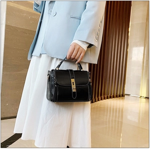 Dettaglio della borsa vintage in pelle cerata nera con cuciture a contrasto e chiusura