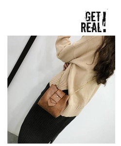 Brown faux leather bucket bag with gold chain strap shown on a fashion model