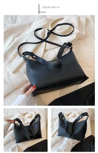 Detailaufnahme der schwarzen Ledertasche mit Litschi-Struktur und gewebten Henkeln