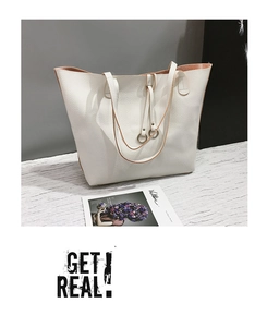 Close-up of white lychee texture tote bag featuring metal ring accents and contrast strap