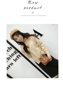 Detail of a brown leather mini bucket bag with gold chain strap on a stylish model