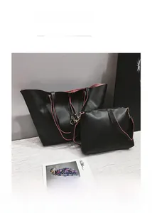 Detail of black pebbled leather tote set with pink contrast edges and matching pouch
