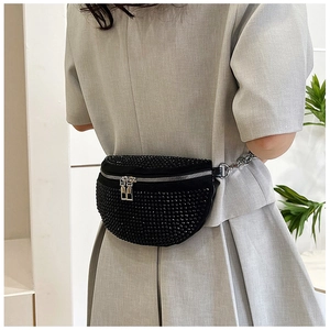 Détail du sac banane noir avec strass et fermetures éclair argentées sur modèle